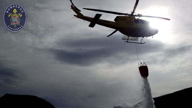 Un helicóptero, bomberos y brigadas forestales participan en la extinción de un incendio en la Sierra de la Fausilla